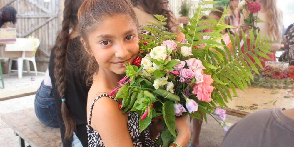 Geschenkspende BuKi: Ein Mädchen mit Blumen in der Hand in Rumänien